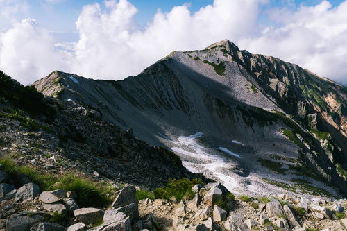 ガスから姿を現した北薬師岳の尾根と岩場の山頂風景