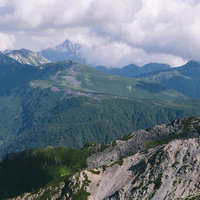 薬師岳の山頂から眺める槍ヶ岳と北アルプスの山並みの写真
