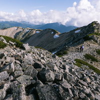 薬師岳の山頂稜線を歩くハイカーたちの写真