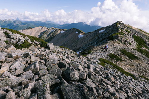 薬師岳の山頂稜線を歩くハイカーたち