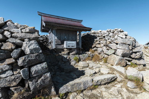 木曽駒ヶ岳山頂の岩場に建つ神社と登山道の風景