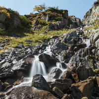 木曽駒ヶ岳の稜線から染み出る渓流と岩肌の渓谷風景の写真