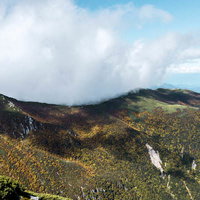 木曽駒ヶ岳の稜線に覆いかぶさる雲と青空、中央アルプスの絶景の写真