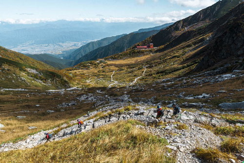 秋の千畳敷カールを下る登山者たちと草紅葉の景観