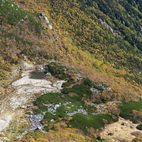 木曽駒ヶ岳の稜線から見下ろす紅葉の濃ヶ池の写真