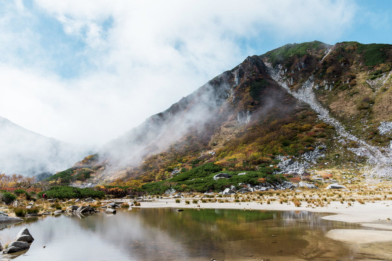 木曽駒ヶ岳の濃ヶ池に雲が映り込む山岳風景