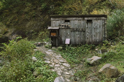 妙高山の河原の湯にある木造の小屋と露天風呂