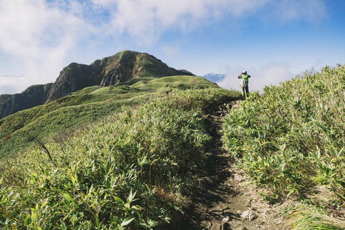 日本百名山・雨飾山の稜線を歩く登山者の風景