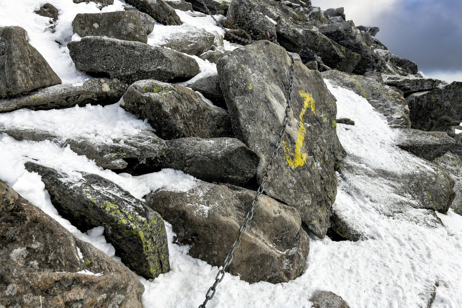雪に覆われた蓼科山の登山道に設置された黄色い矢印と鎖