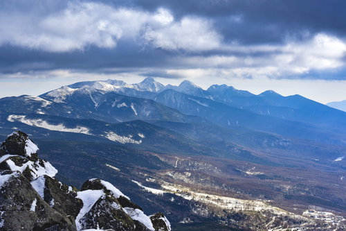 雲の向こうに見える雪化粧の蓼科山と八ヶ岳連峰