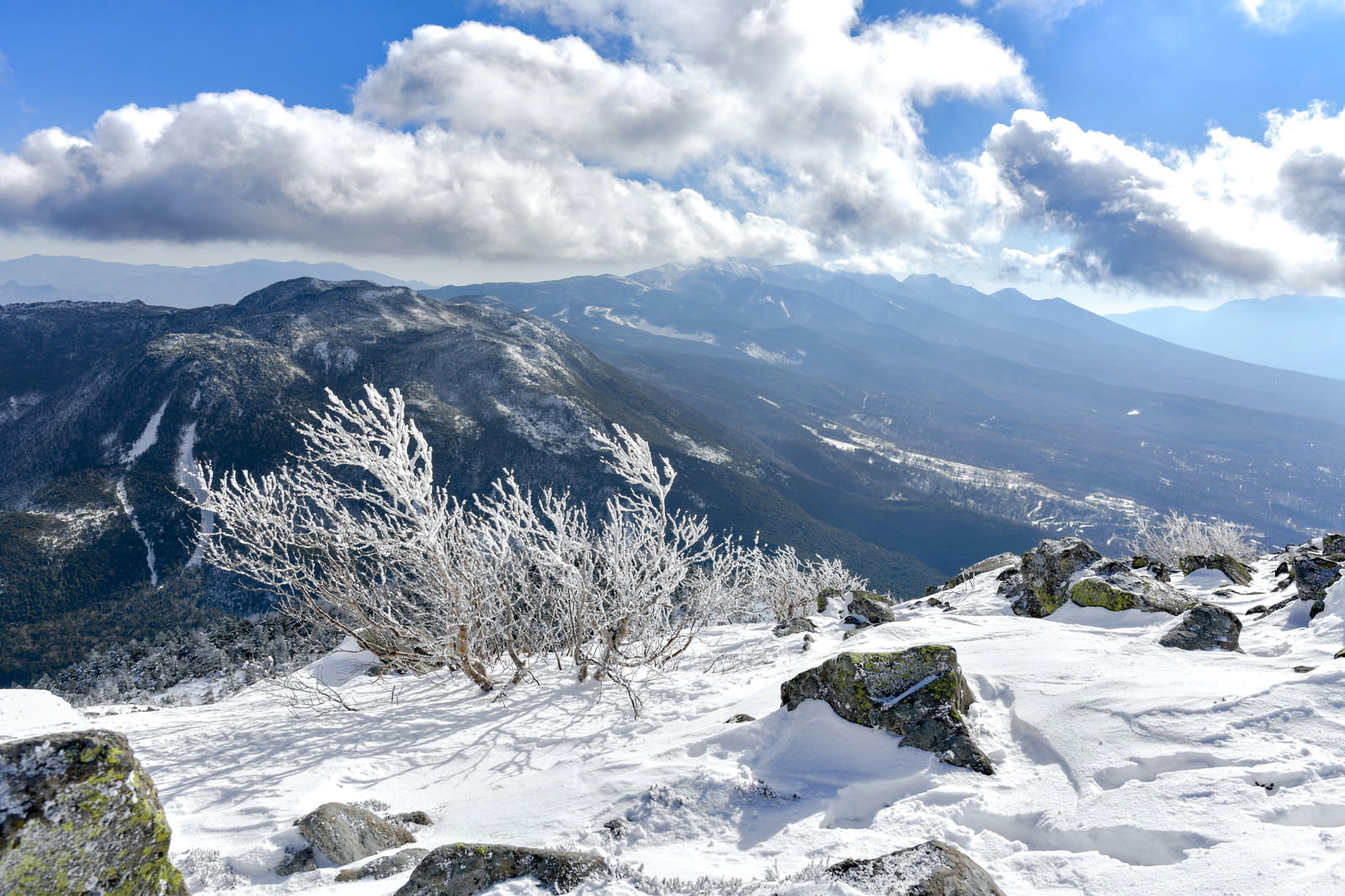 蓼科山から見た霧氷に覆われた岩場と雪化粧した八ヶ岳の山並み