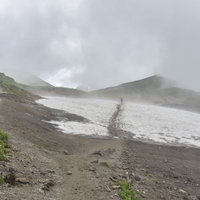 鷲羽岳の弓折乗越でガスの稜線を歩く登山者の写真