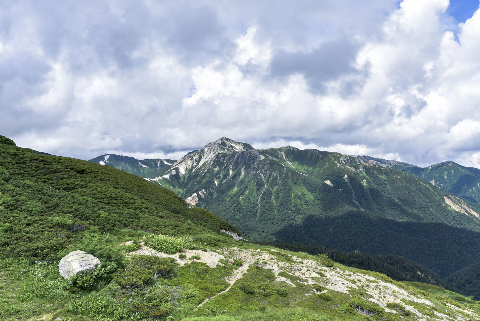 双六岳手前から望む鷲羽岳と北アルプスの山並み、青空に浮かぶ雲