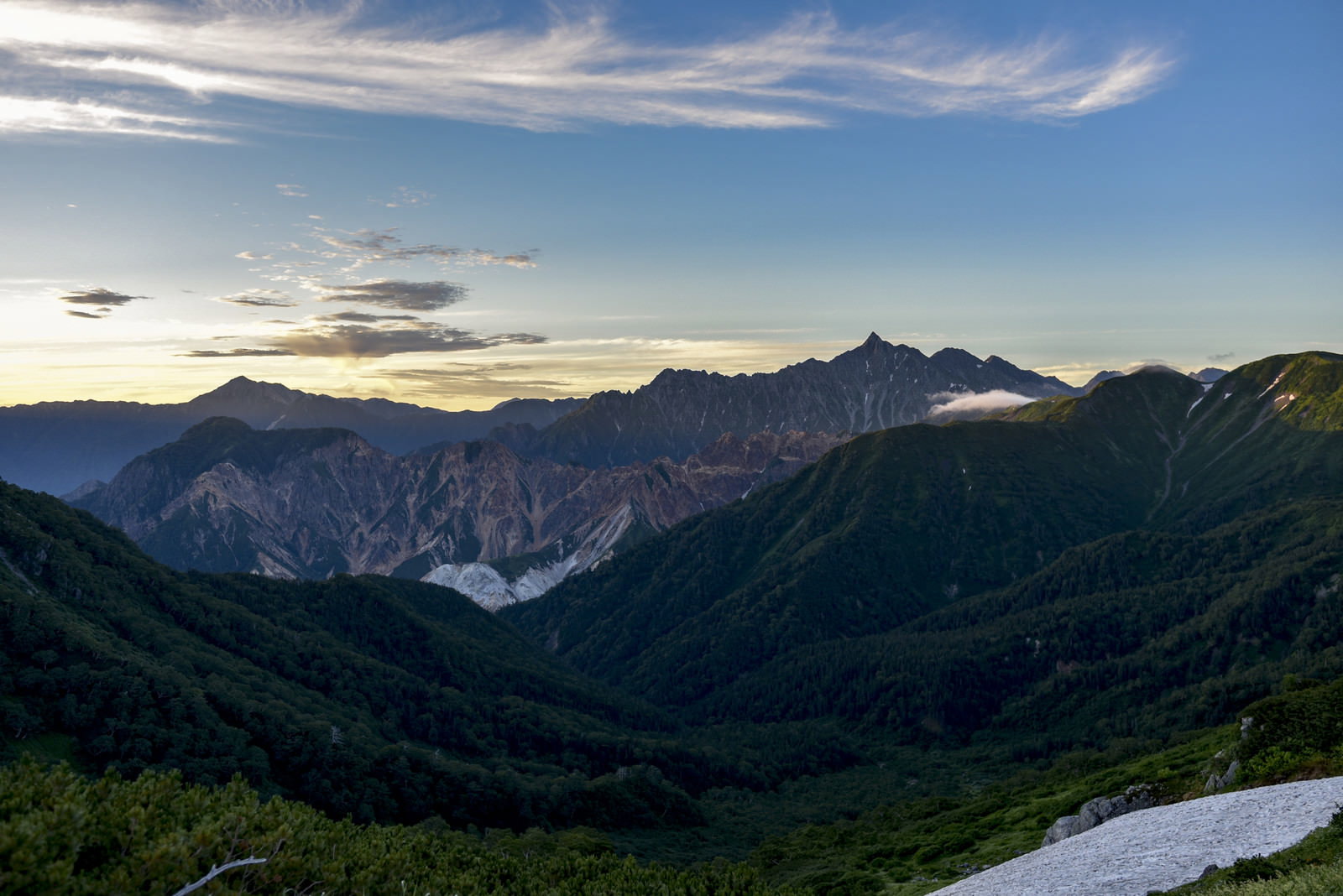夜明けの光に照らされた槍ヶ岳と北アルプスの山並み
