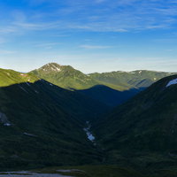 朝日を受ける黒部五郎岳と鷲羽岳の山並み・日本百名山の雄大な稜線の写真