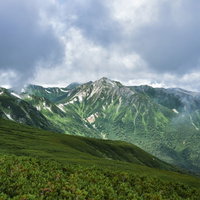 雲の隙間から顔を見せる日本百名山の鷲羽岳の写真