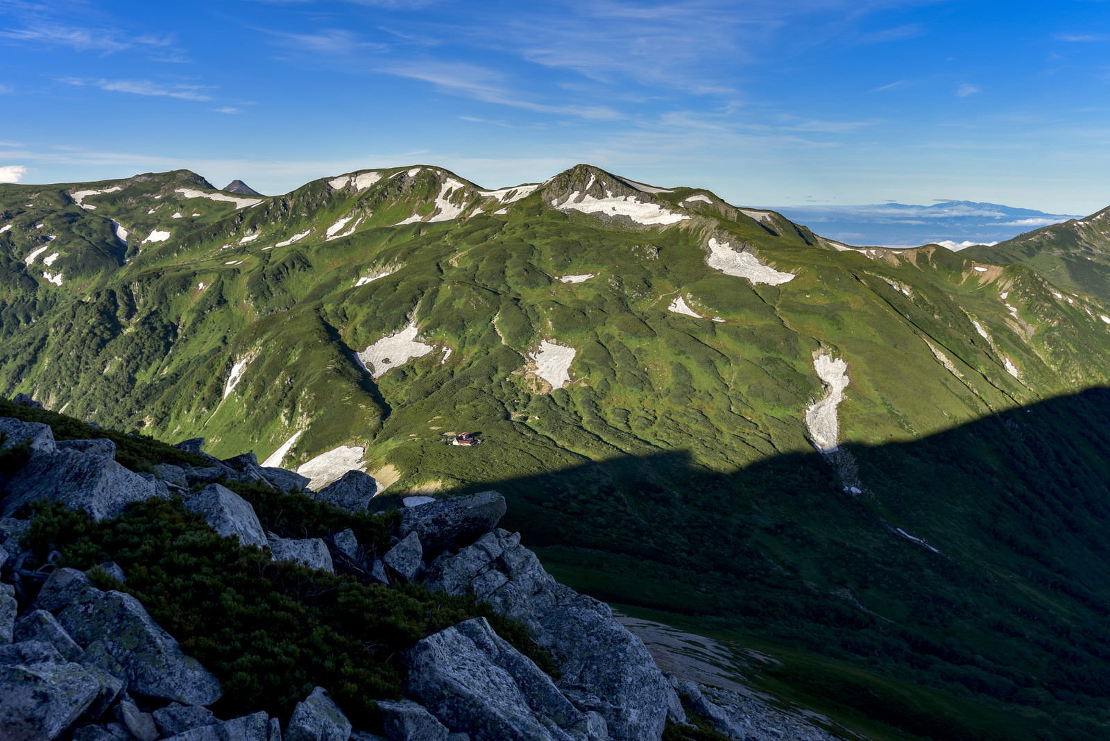 鷲羽岳から望む三俣蓮華岳と谷間の三俣蓮華小屋の山岳風景