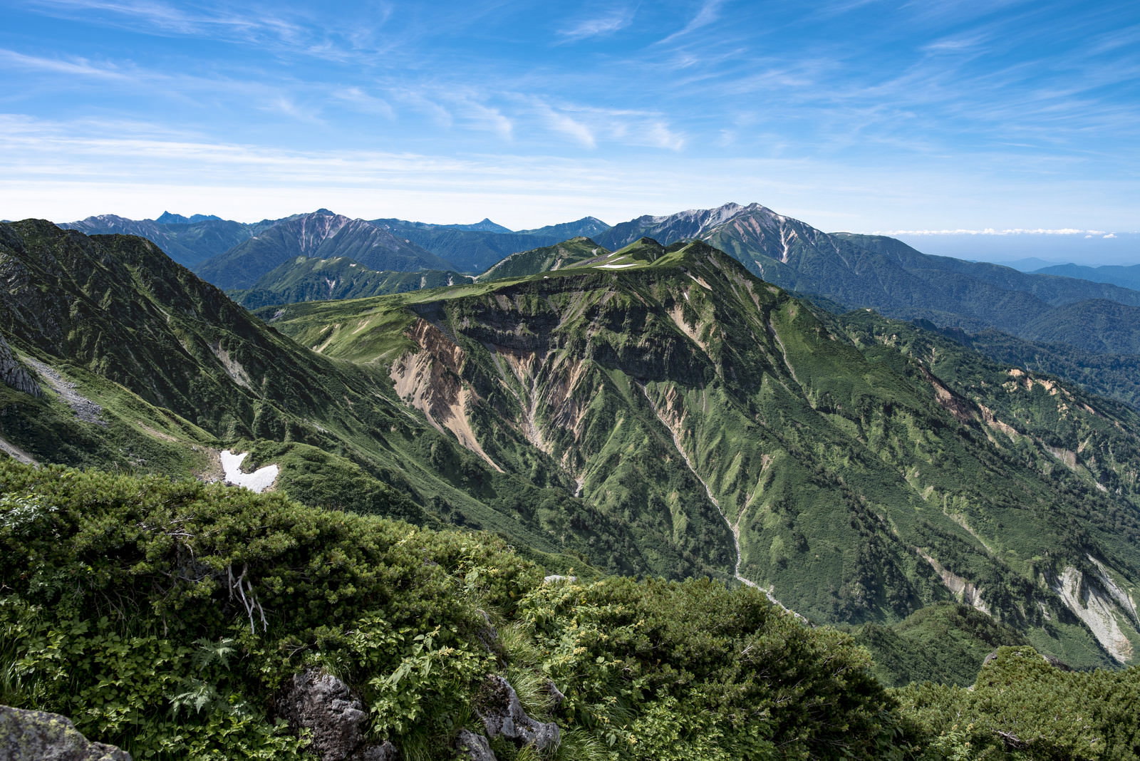 立山の五色ヶ原を遠景で撮影した山岳風景、緑の山々と青空