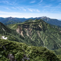立山の五色ヶ原を遠景に望む連峰と青空の山岳風景の写真