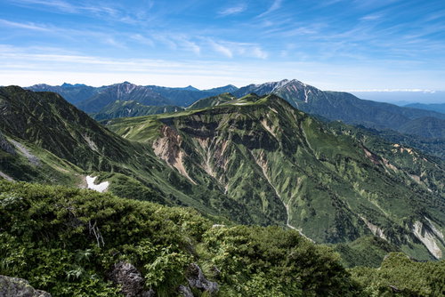 立山の五色ヶ原を遠景に望む連峰と青空の山岳風景