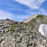 別山へと続くなだらかな稜線を歩く立山の登山道の写真