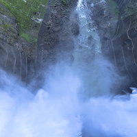 激しく放水を行う黒部ダムを上から見る立山の日本百名山の写真