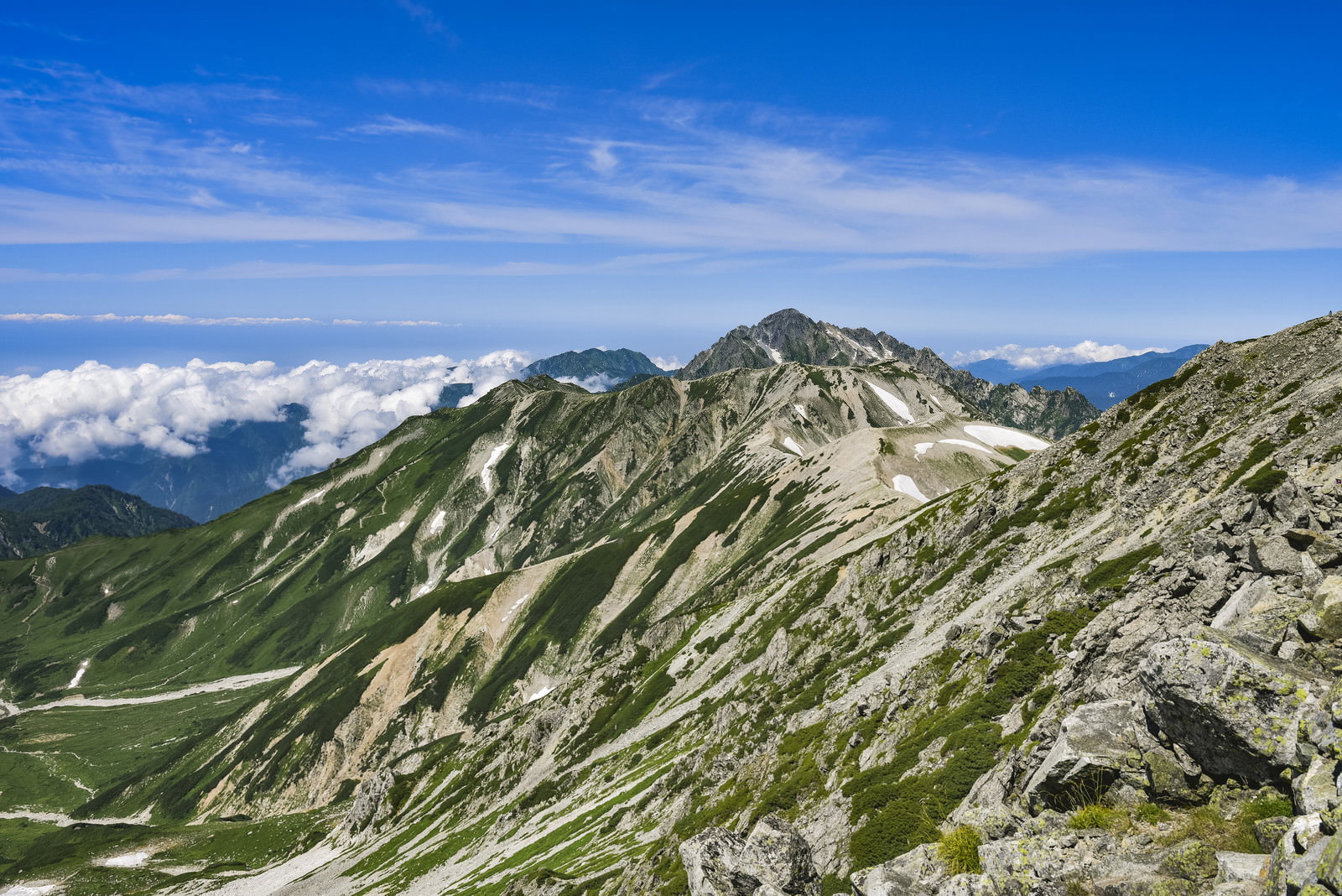 青空の下、立山の登山道から眺める剱岳の険しい岩肌と山稜線