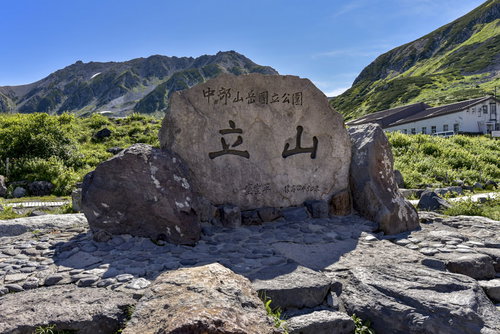 立山を知らせる巨大な石の碑と青空、日本百名山の山頂景観