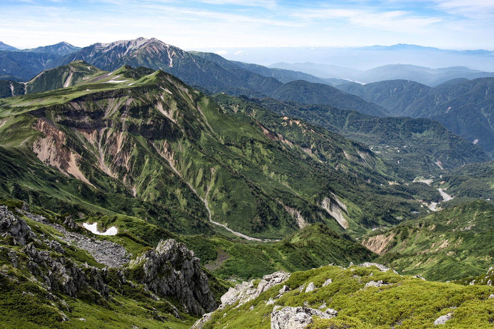 立山カルデラから見下ろす緑の山々と山麓の風景