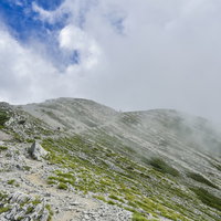 ガスに包まれる立山別山付近の登山道と稜線（剱岳）の写真