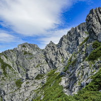 剱岳の急峻な岩稜を下る登山者たち、切り立った絶壁と岩肌の写真