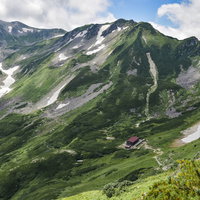 剱岳別山尾根から見る剣山荘方面と残雪の山岳風景の写真