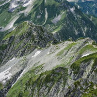 剱岳別山尾根の険しい登山道を見下ろす北アルプスの稜線の写真