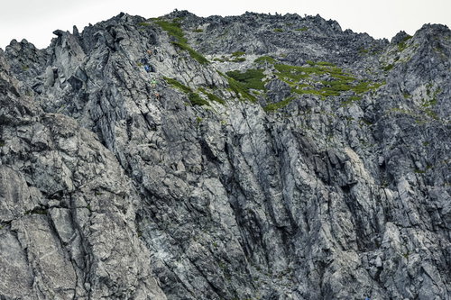 日本百名山・剱岳の険しい岩稜を登る登山者