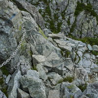 岩肌に鎖が付けられた剱岳の登山道の写真
