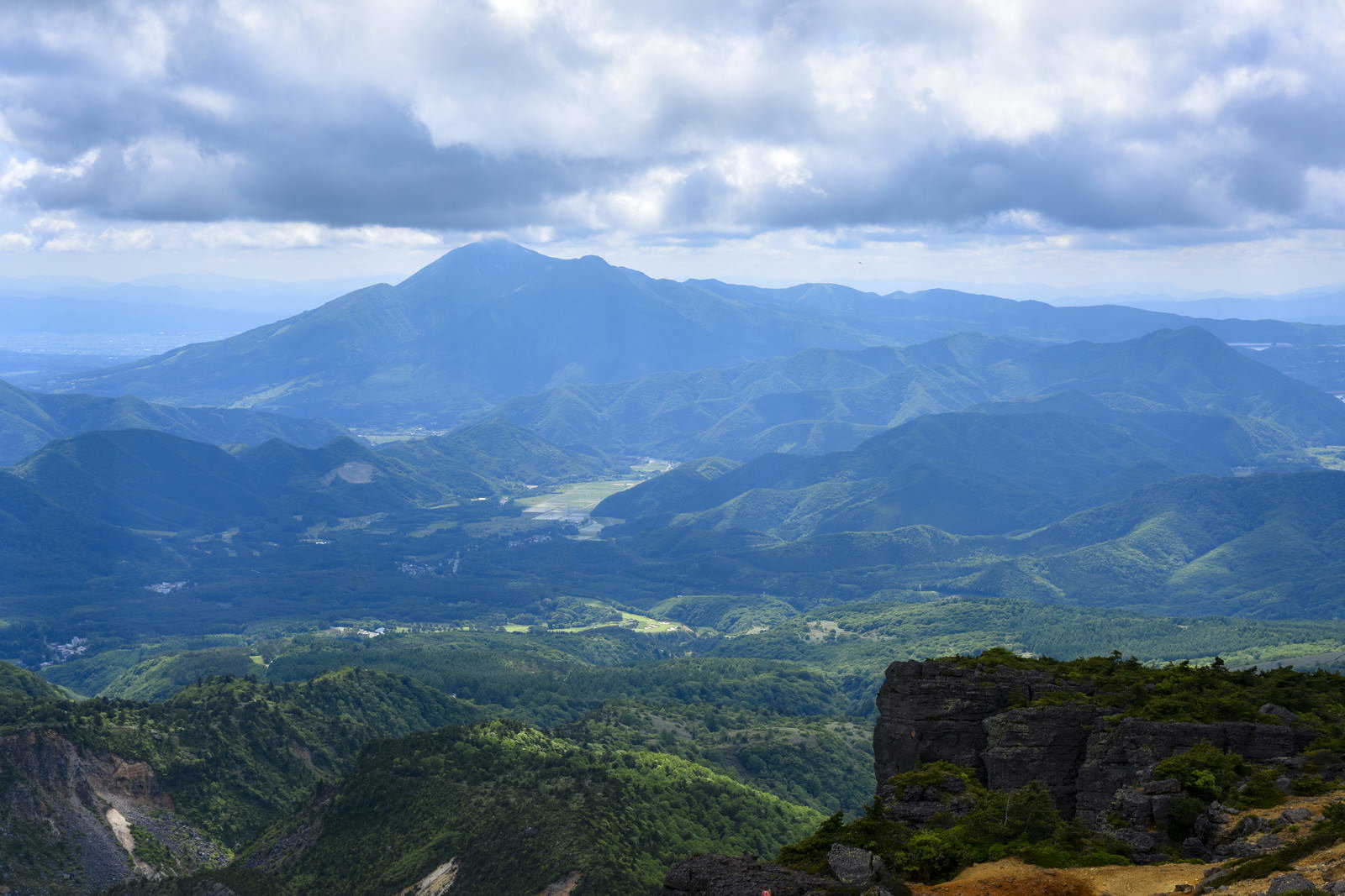 安達太良山から眺める新緑に覆われた磐梯山方面の山々と青空