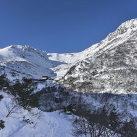 雪化粧した安達太良山とくろがね小屋を望む冬の山頂方面の写真