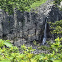 安達太良山の白糸の滝と岩壁から流れ落ちる水流の写真