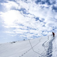 日本百名山・安達太良山を登る登山者たちと雪面のトレースの写真