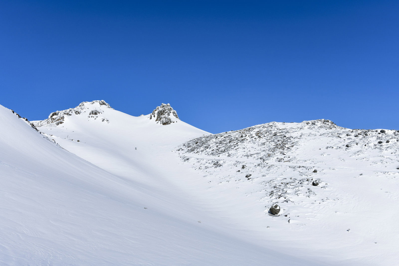 雪に覆われた安達太良山の山頂方面と青空の冬山風景