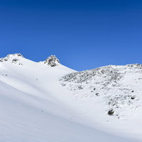 安達太良山中腹から見る雪化粧した山頂方面の写真
