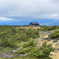 新緑に囲まれる鉄山避難小屋（安達太良山）の写真