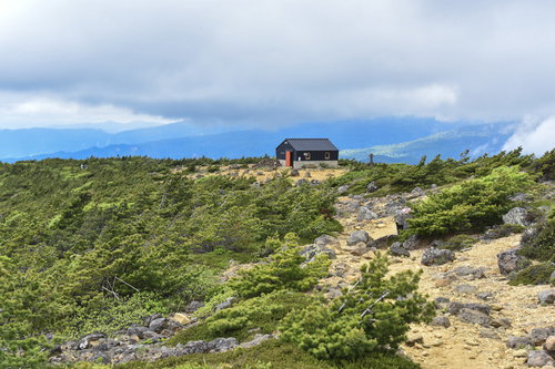 新緑に囲まれる鉄山避難小屋（安達太良山）