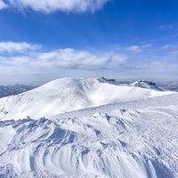 穏やかな雪の斜面の船明神山、安達太良山の山頂からの写真