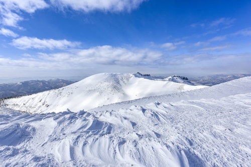 穏やかな雪の斜面の船明神山、安達太良山の山頂から