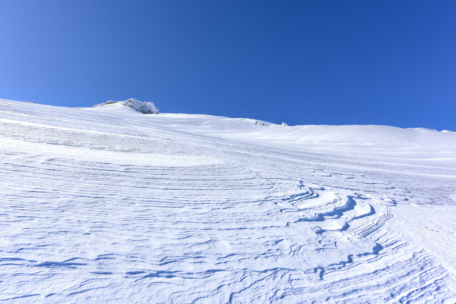 安達太良山の雪の斜面に風によってできた風紋模様と青空