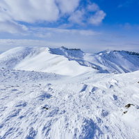 雪に覆われた稜線が続く船明神山方面（安達太良山）の写真