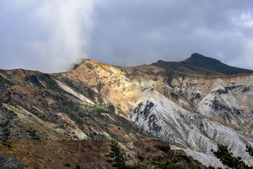 雲に包まれる安達太良山の爆裂火口と火山地形の斜面