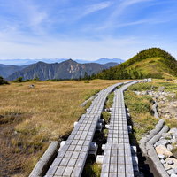苗場山の檜ノ塔へと向かう湿原の木道と青空の写真
