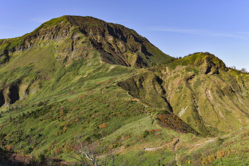 鞍部から見上げる苗場山の雄大な山容と登山道の眺望